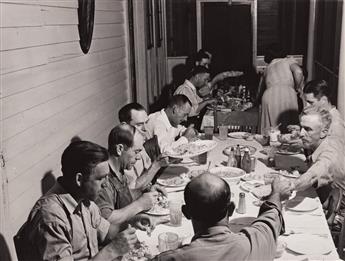 JACK DELANO (1914-1997) Man speaking to group * Workers from the nearby powder plant having dinner at their boarding house in Childersb